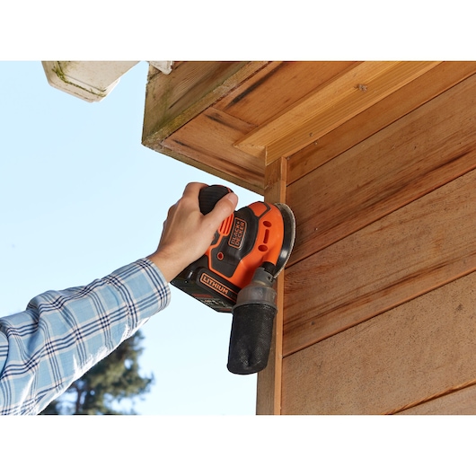 Photo of BLACKDECKER BDCROS18 cordless sander used on wooden exterior siding.