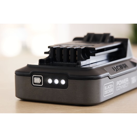 BLACK+DECKER BDL2018S lithium battery pack with three LED indicator lights, side angle on wooden surface.