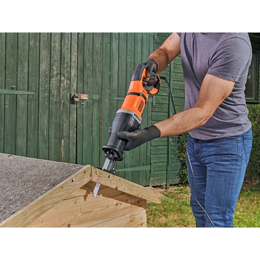 BLACKDECKER BES301 reciprocating saw in use cutting wood outdoors.