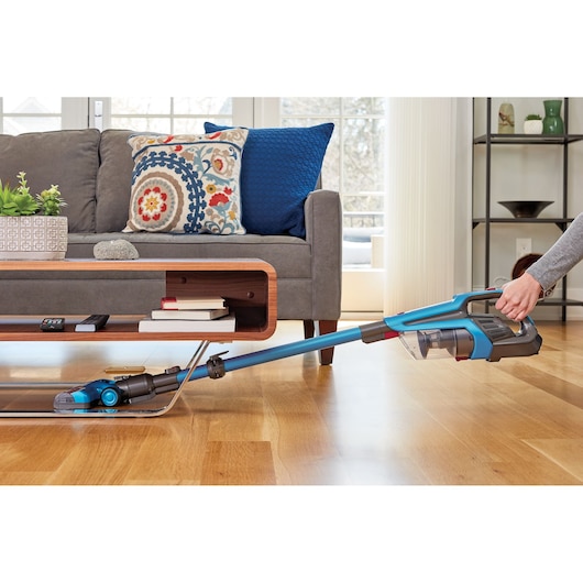 BLACKDECKER BHFE520J stick vacuum cleaning hardwood floor in living room, side angle.