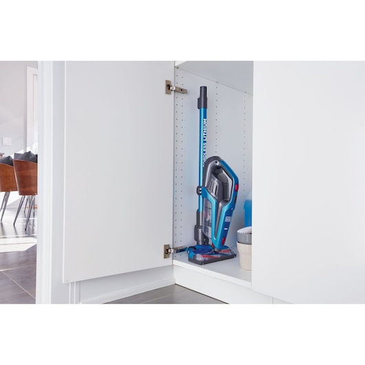 Photo of BLACKDECKER BHFE520J cordless stick vacuum cleaner stored upright in white cabinet.
