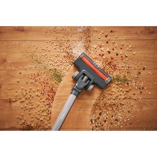 BLACKDECKER BHFEA515JB cordless vacuum cleaner head picking up debris from hardwood floor, top view.
