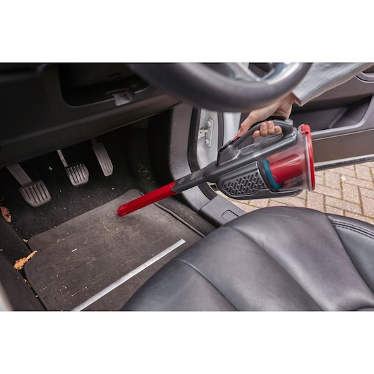 BLACKDECKER BHHV315J handheld vacuum cleaning car floor mat with red slim nozzle.