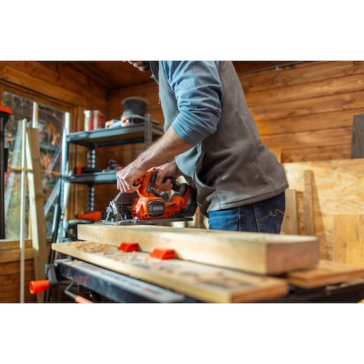 BLACKDECKER BLCCS78N cordless circular saw in use cutting wood in a workshop.