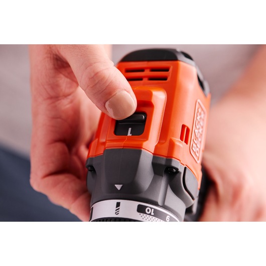 Close-up photo of hand adjusting speed switch on BLACKDECKER BLD682D1 orange and black cordless power drill.