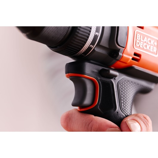 Close-up photo of BLACK+DECKER BLD682D1 drill, focusing on the black and orange ergonomic grip and trigger.