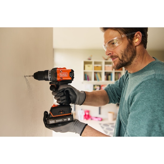 BLACKDECKER BLD682XN cordless drill in use drilling a wall, orange and black design, photography