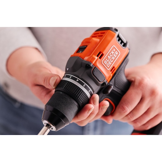 BLACK+DECKER BLD682XN cordless drill in use, close-up of orange and black handle and chuck being adjusted.