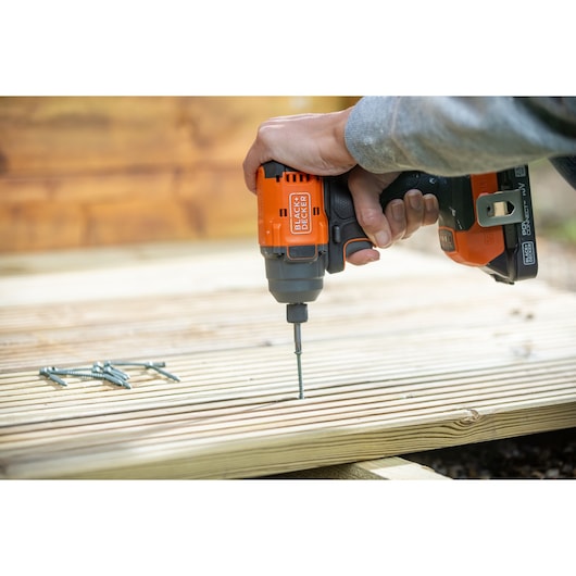 BLACKDECKER cordless drill BLIM78N used to drive screws into wooden decking, close-up view.