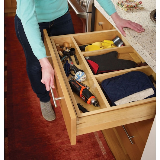 BLACKDECKER CS3653LC cordless screwdriver in kitchen drawer with tools and accessories, angled view.