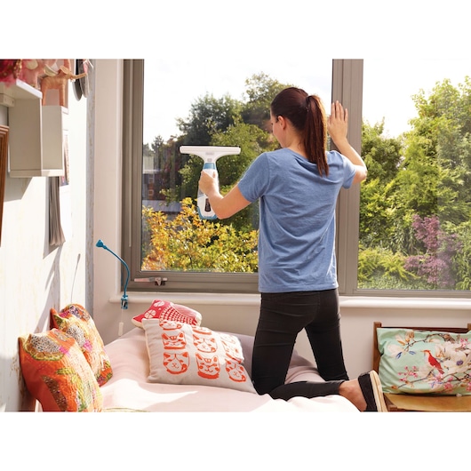 BLACKDECKER WW100 window vacuum cleaner used for cleaning glass in bright bedroom setting.